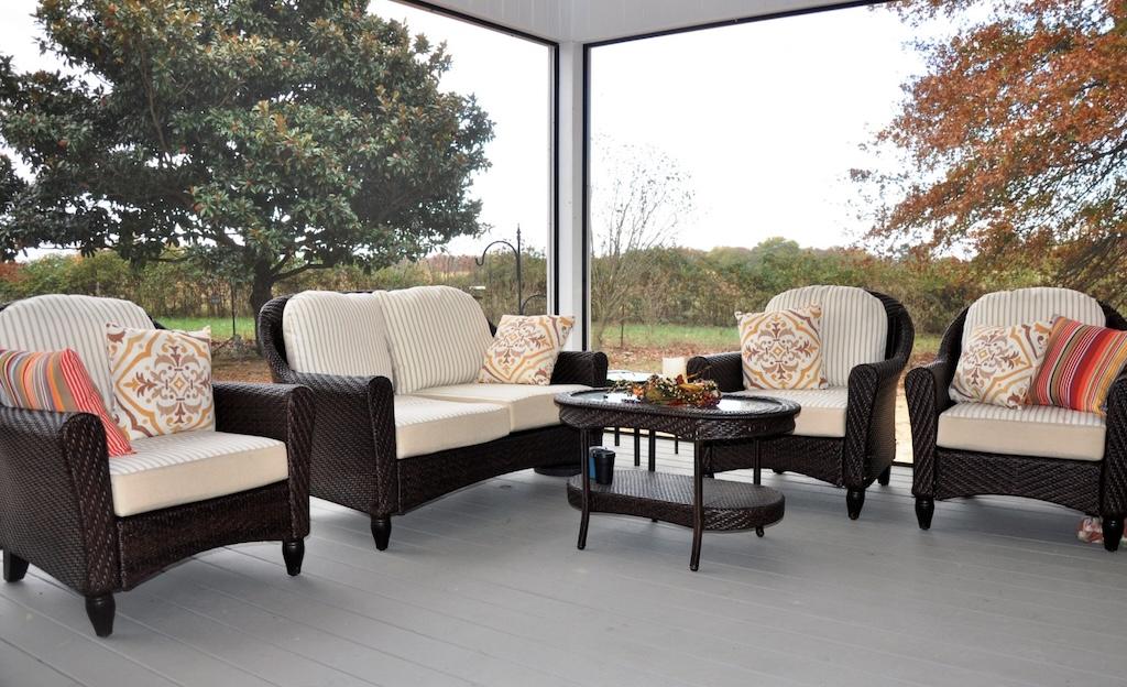 Photo of porch area with whitewashed flooring and drop screens built into the ceiling and post of the porch